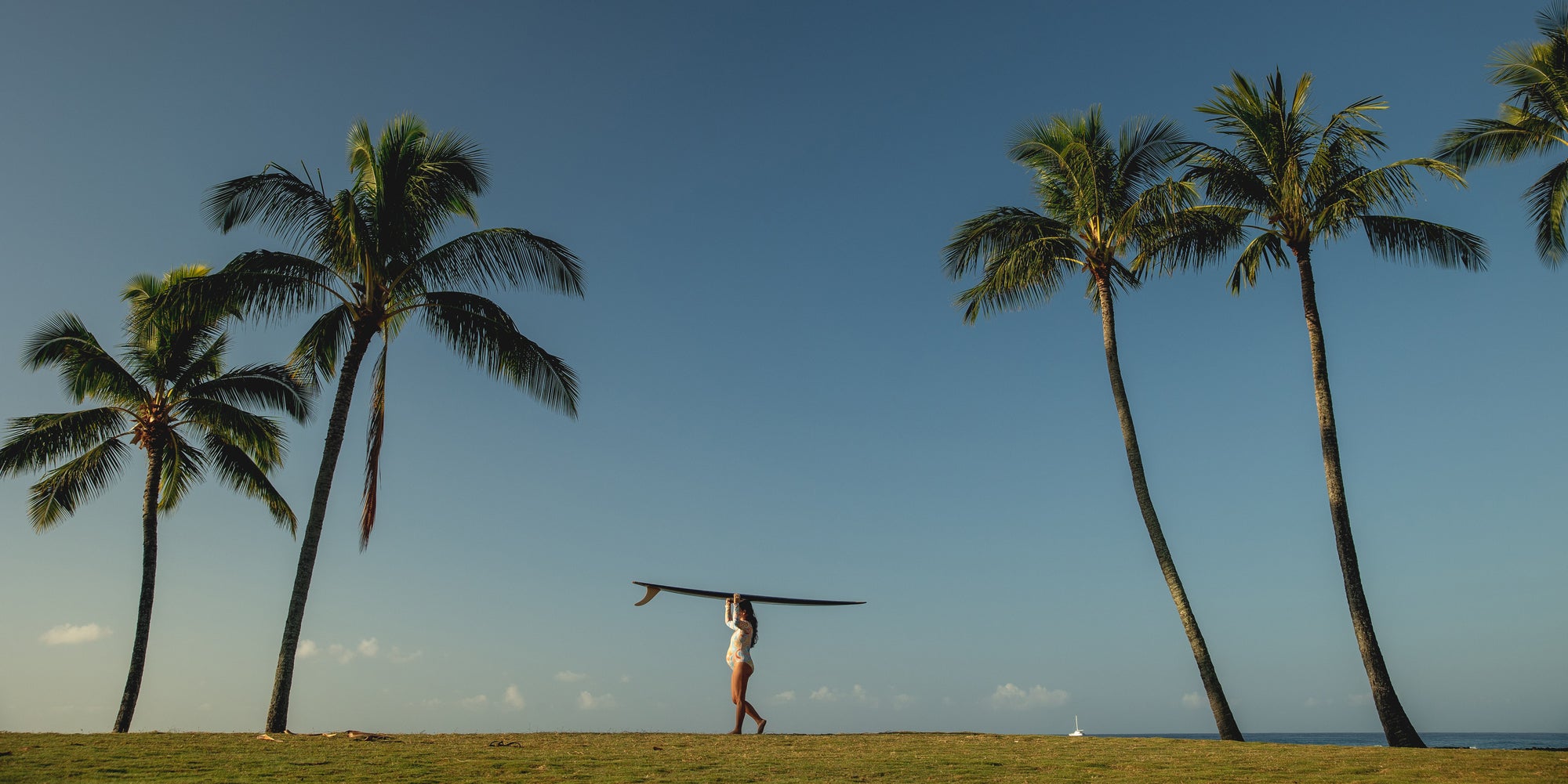 Pregnant surfer walking with surf board